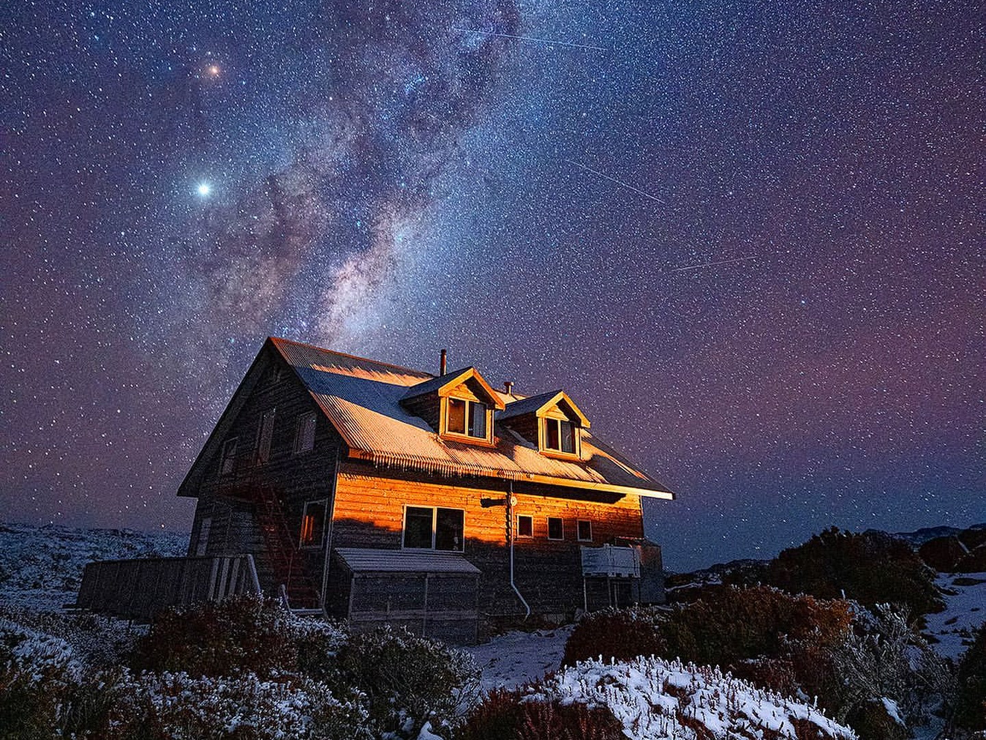 Snow-dusted lodge beneath the Milky Way at Ben Lomond