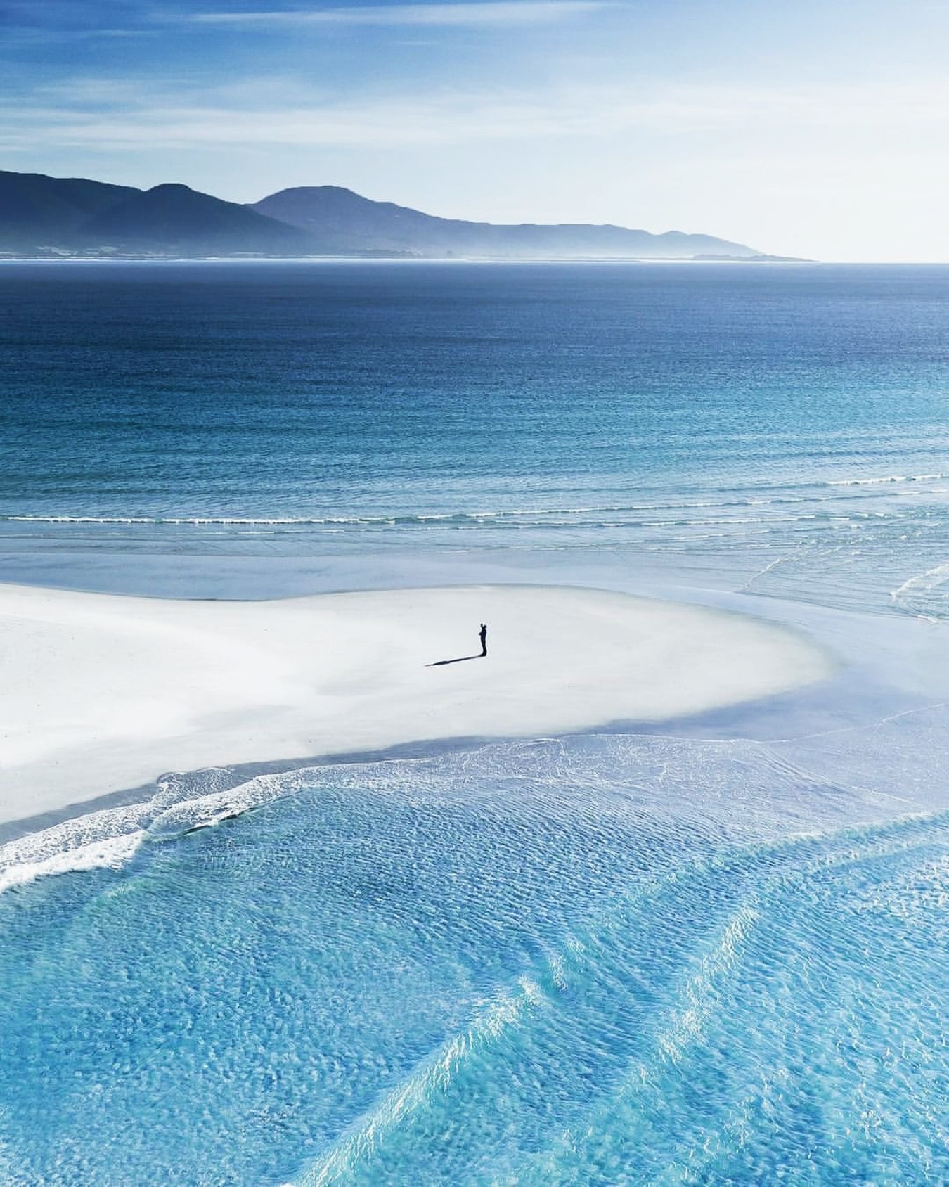 White sand and clear water at Redbill Beach in Bicheno with Diamond Island offshore