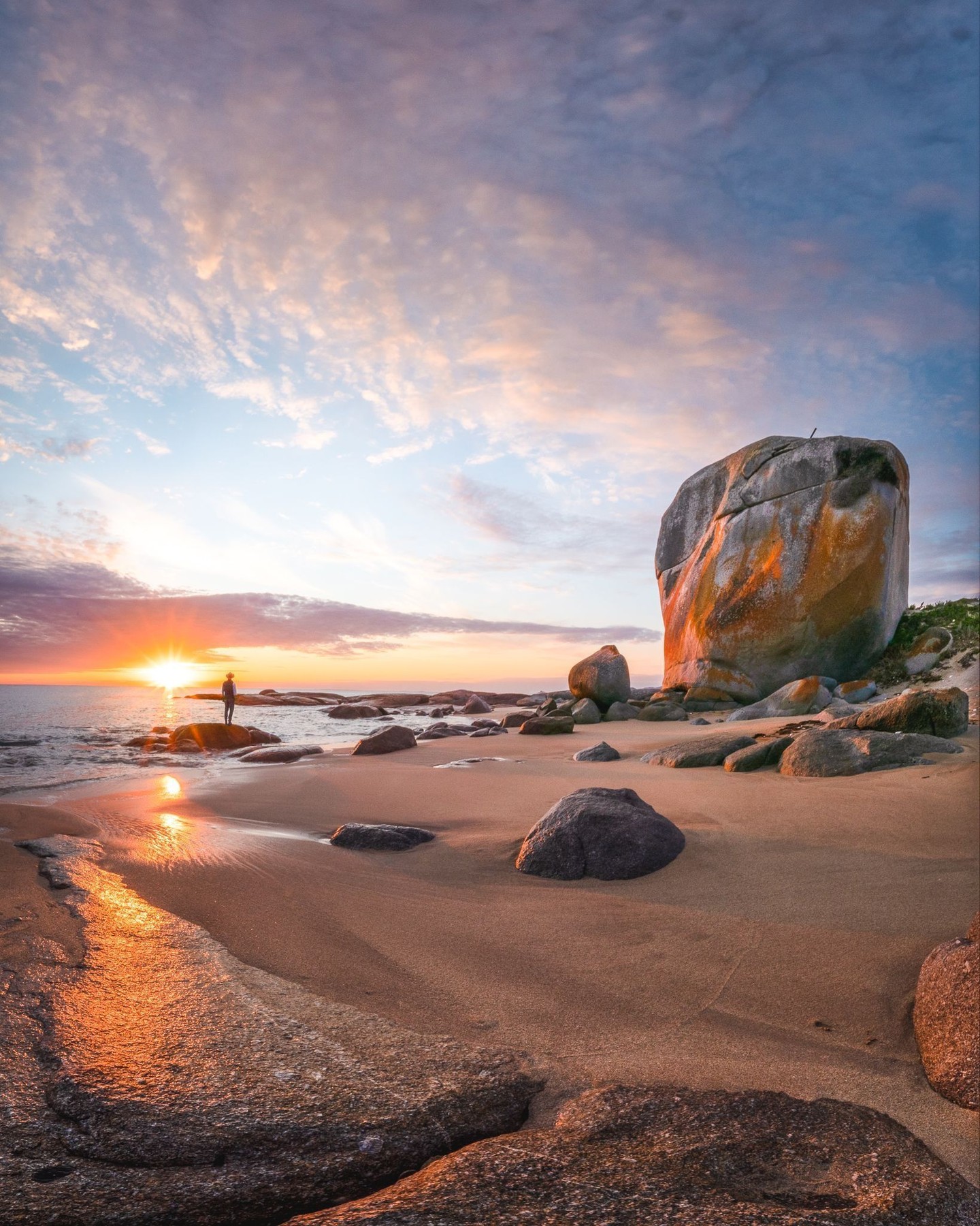 Castle Rock on Flinders Island glowing beside Marshall Bay at sunset