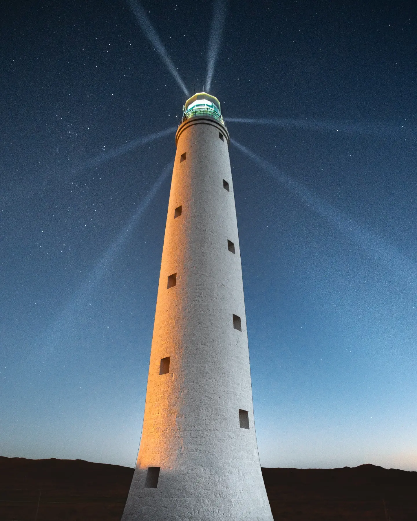 Cape Wickham Lighthouse illuminated beneath a starry night sky on King Island