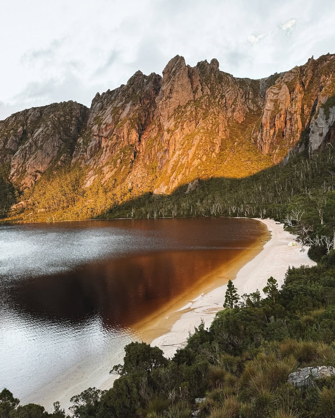 Quartzite beach and dark water at Lake Rhona beneath the Denison Range
