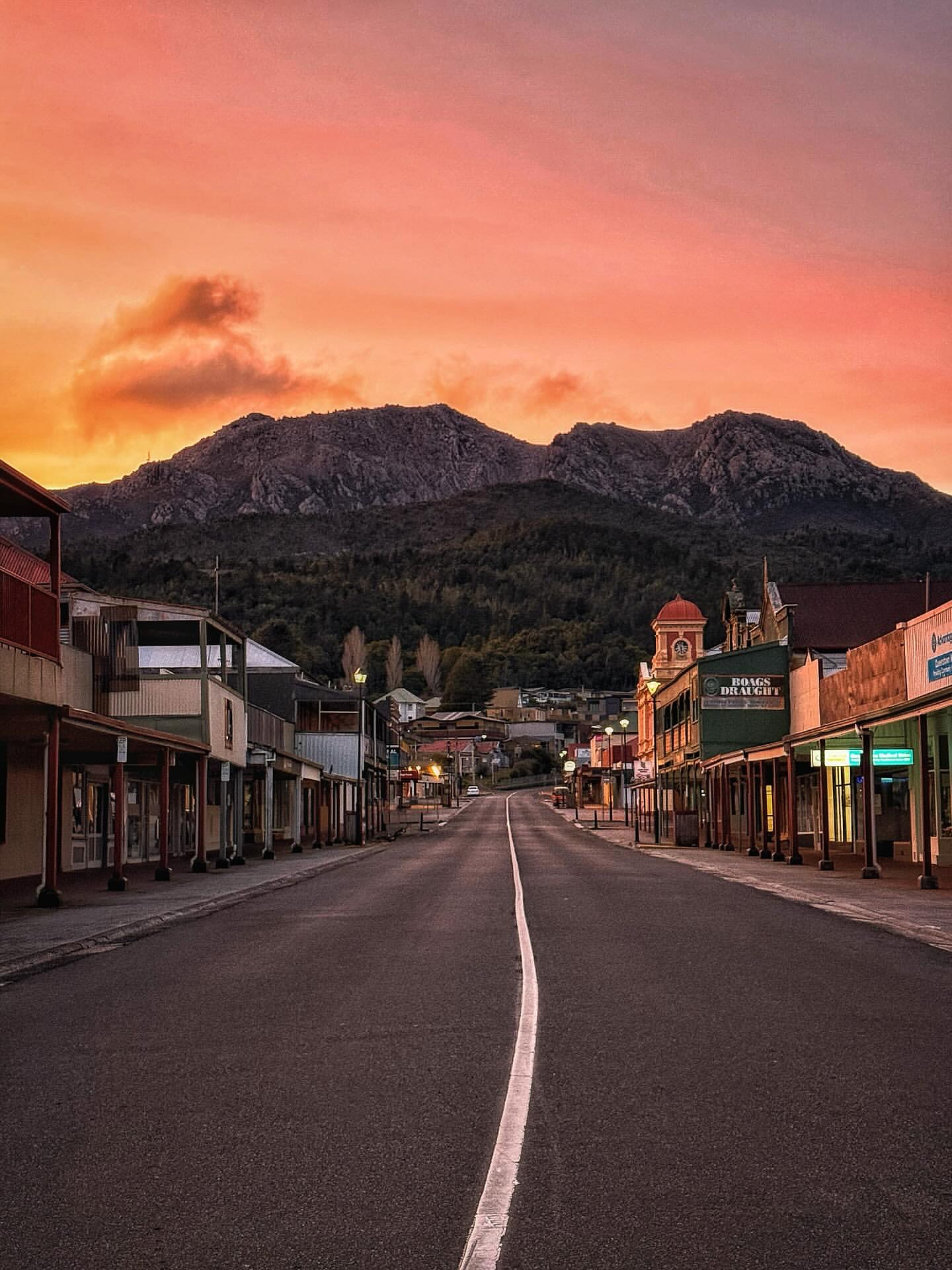 Queenstown main street at sunset with Mount Owen rising behind the town