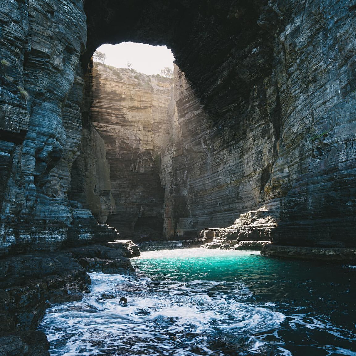 Tasman Arch opening above turquoise water on the Tasman Peninsula